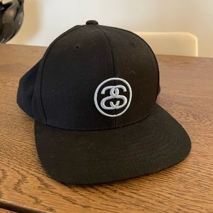 Barely worn black stussy unisex baseball snap back cap/hat with a sky blue logo
